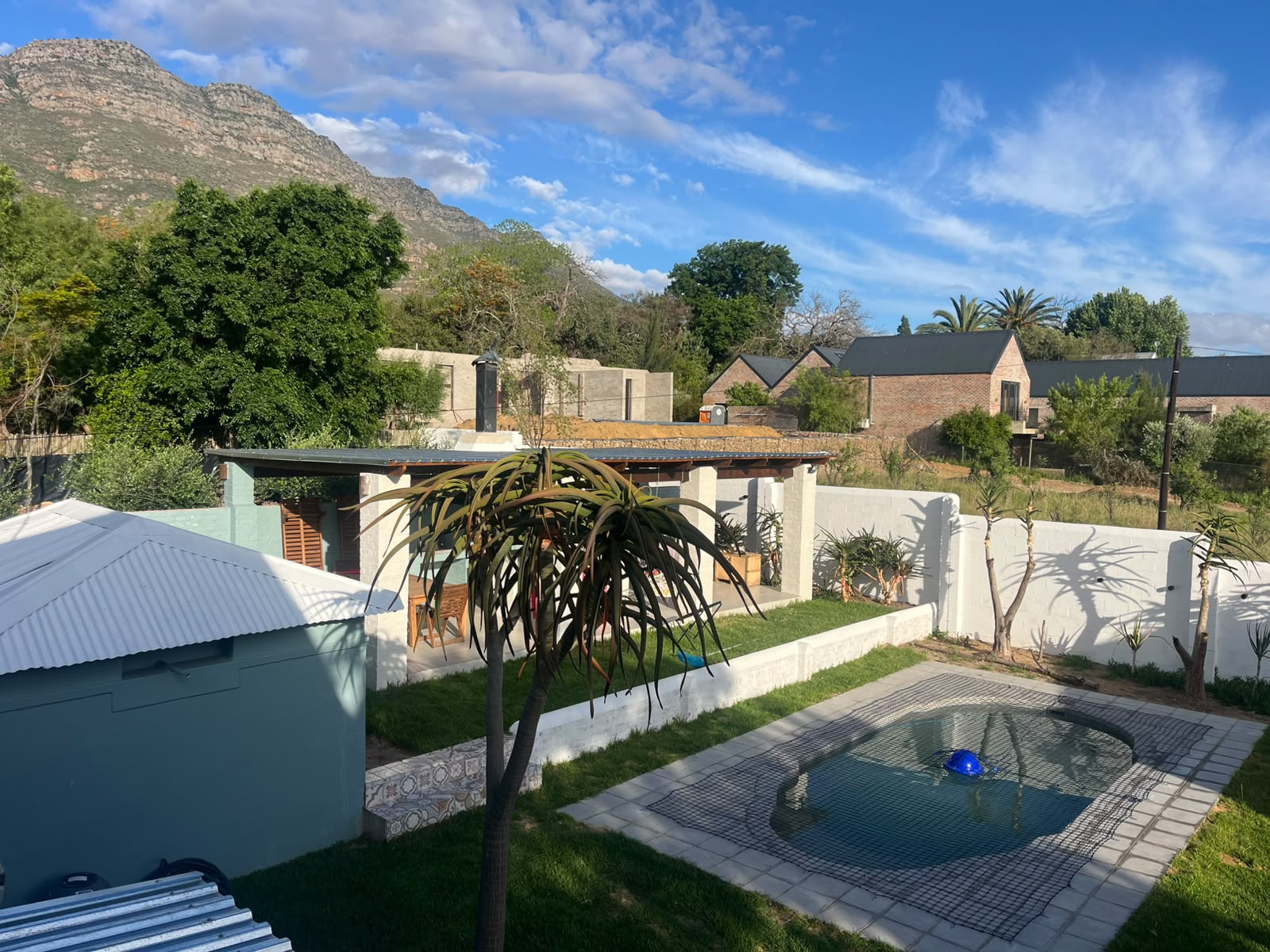 Overview of the swimming pool and recreational area at De Stoep Guesthouse.